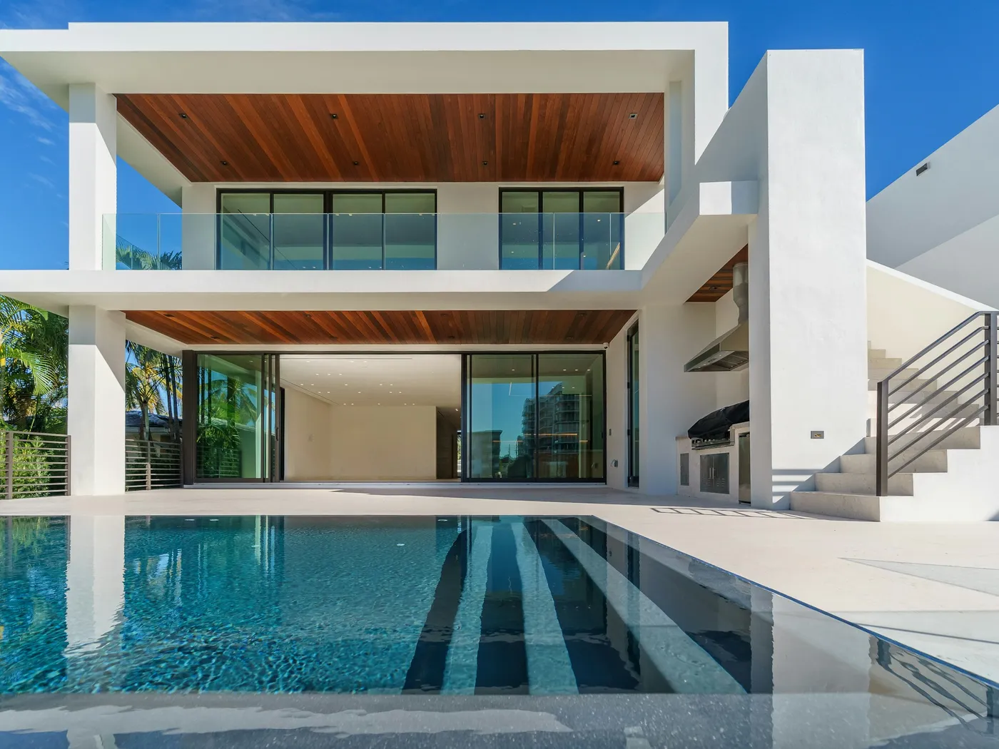 Edificio residencial blanco con terrazas y alberca